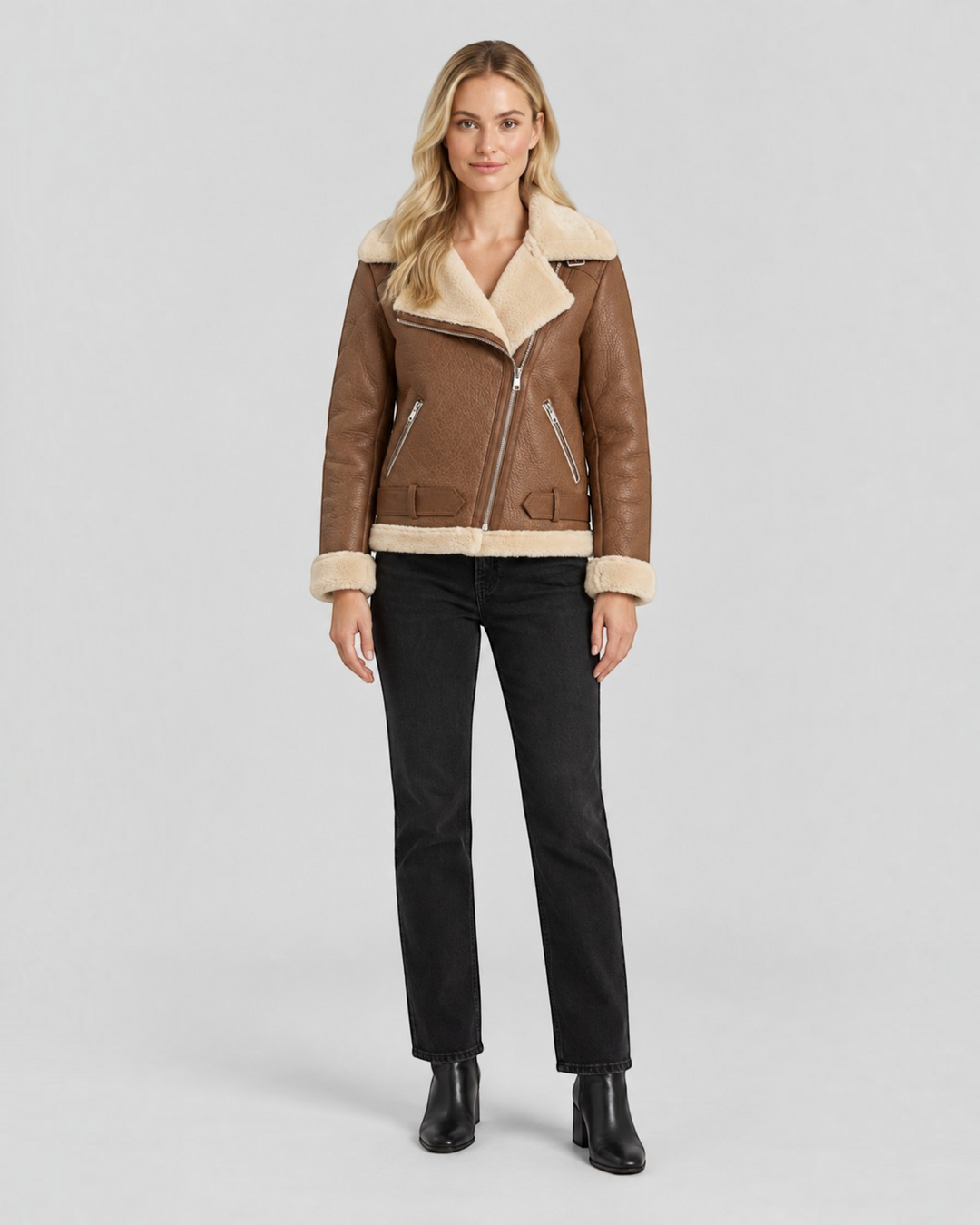 Luna Moda Claudia brown faux leather jacket with cream fleece lining, zip details, and waist belt on a blonde model