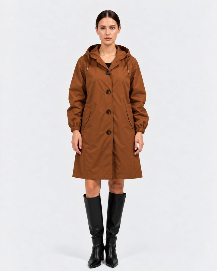 Luna Moda brown oversized waterproof hooded raincoat with button closure and pockets worn by a female model