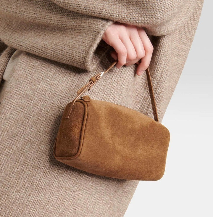 Luna Moda Marisa brown suede shoulder bag held by a person wearing a beige knit sweater