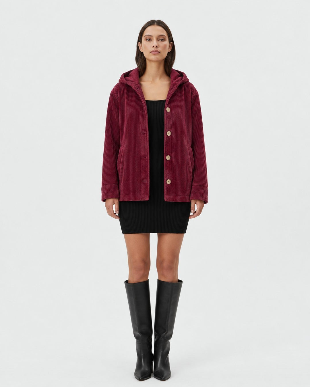 Luna Moda burgundy corduroy hooded jacket with button closure worn by a model over a black dress and boots.