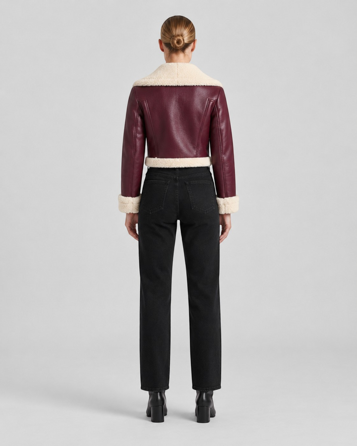 Luna Moda cropped burgundy faux leather jacket with cream fleece lining, back view on a model wearing black jeans.