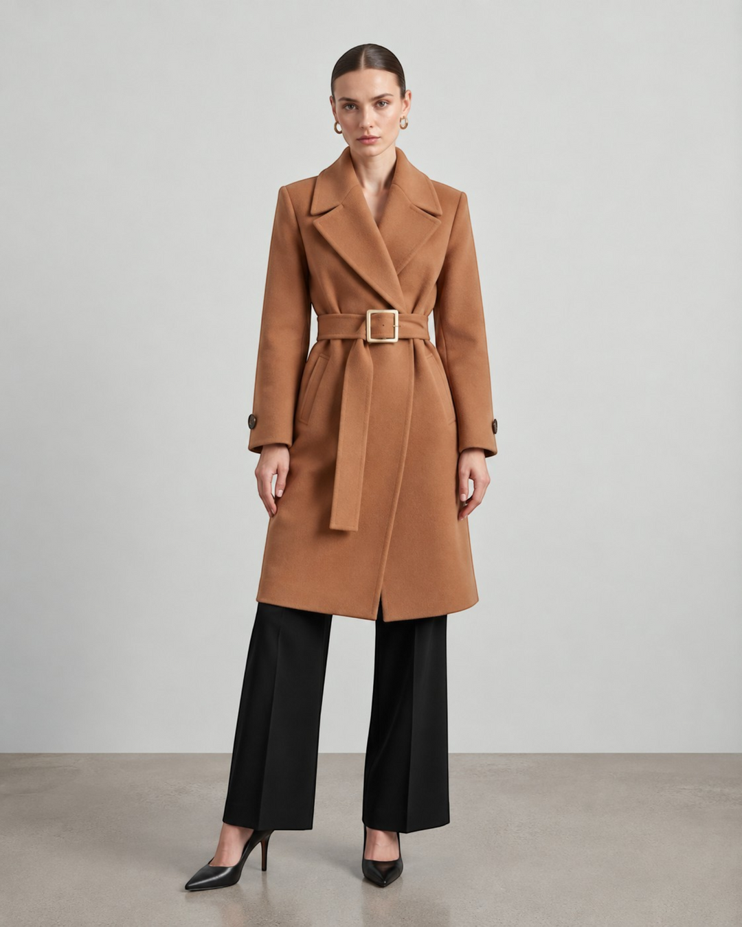 Luna Moda camel wool-blend long coat with a belted waist and wide lapels worn by a model with black trousers