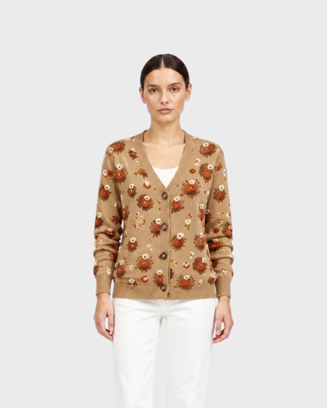 Luna Moda Celia cardigan in tan knit with brown and orange floral pattern, worn with white trousers and black boots.