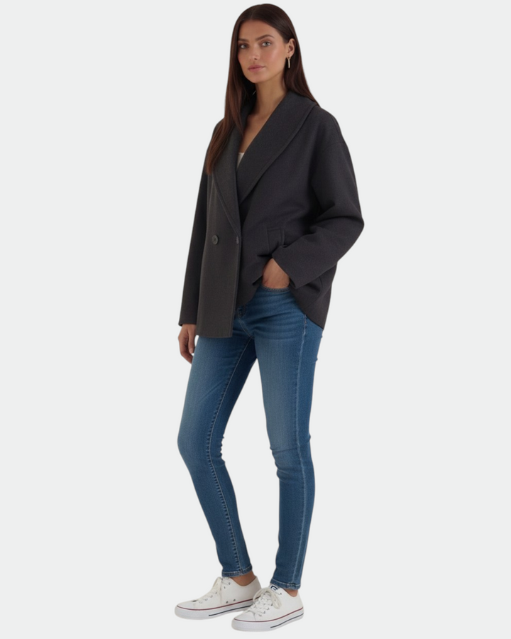 Model wearing a Luna Moda Corinna charcoal grey oversized coat with a wide collar, paired with blue jeans and sneakers