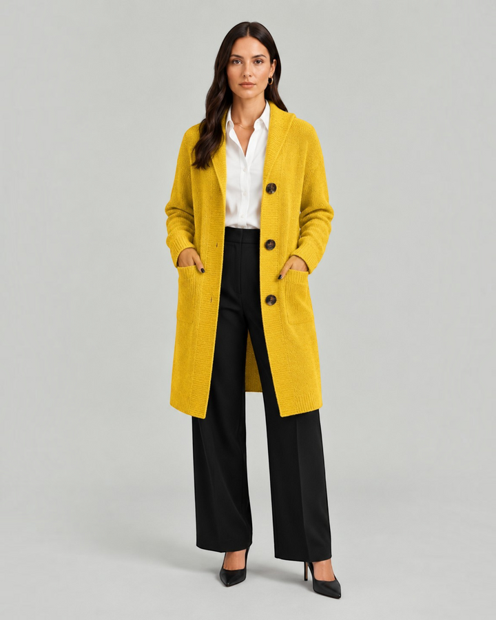 Luna Moda Chiara long yellow knit cardigan with buttons and pockets worn by a model over a white shirt and trousers.