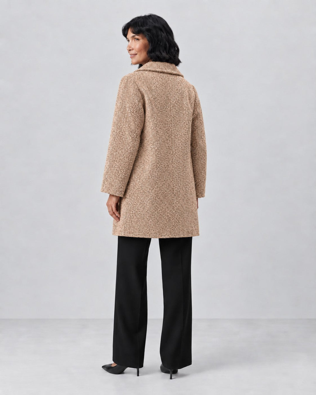 Luna Moda Clara classic tweed jacket in beige herringbone pattern worn by a model, back view.