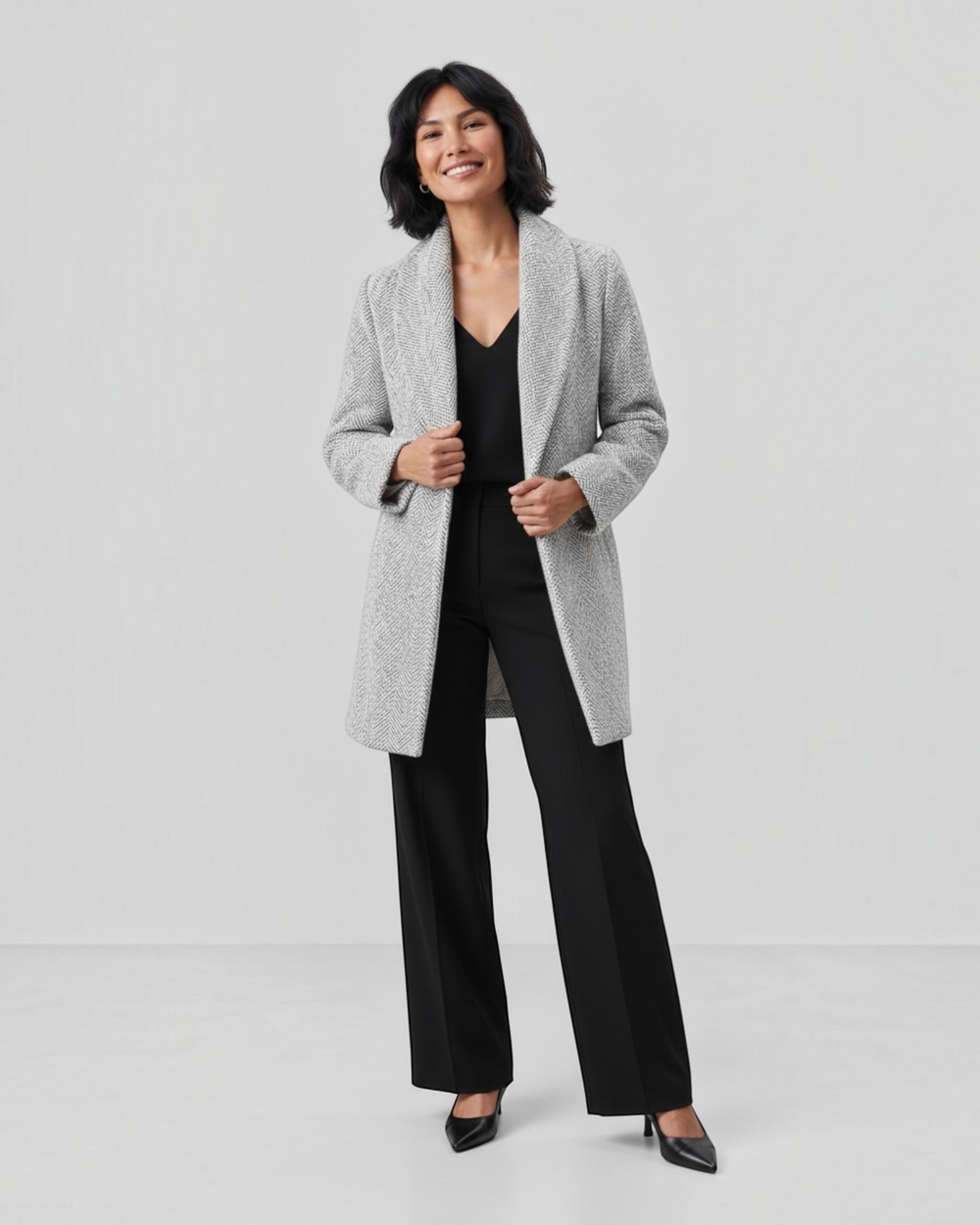 Luna Moda Clara grey tweed jacket with a classic cut worn by a smiling woman in black trousers and heels