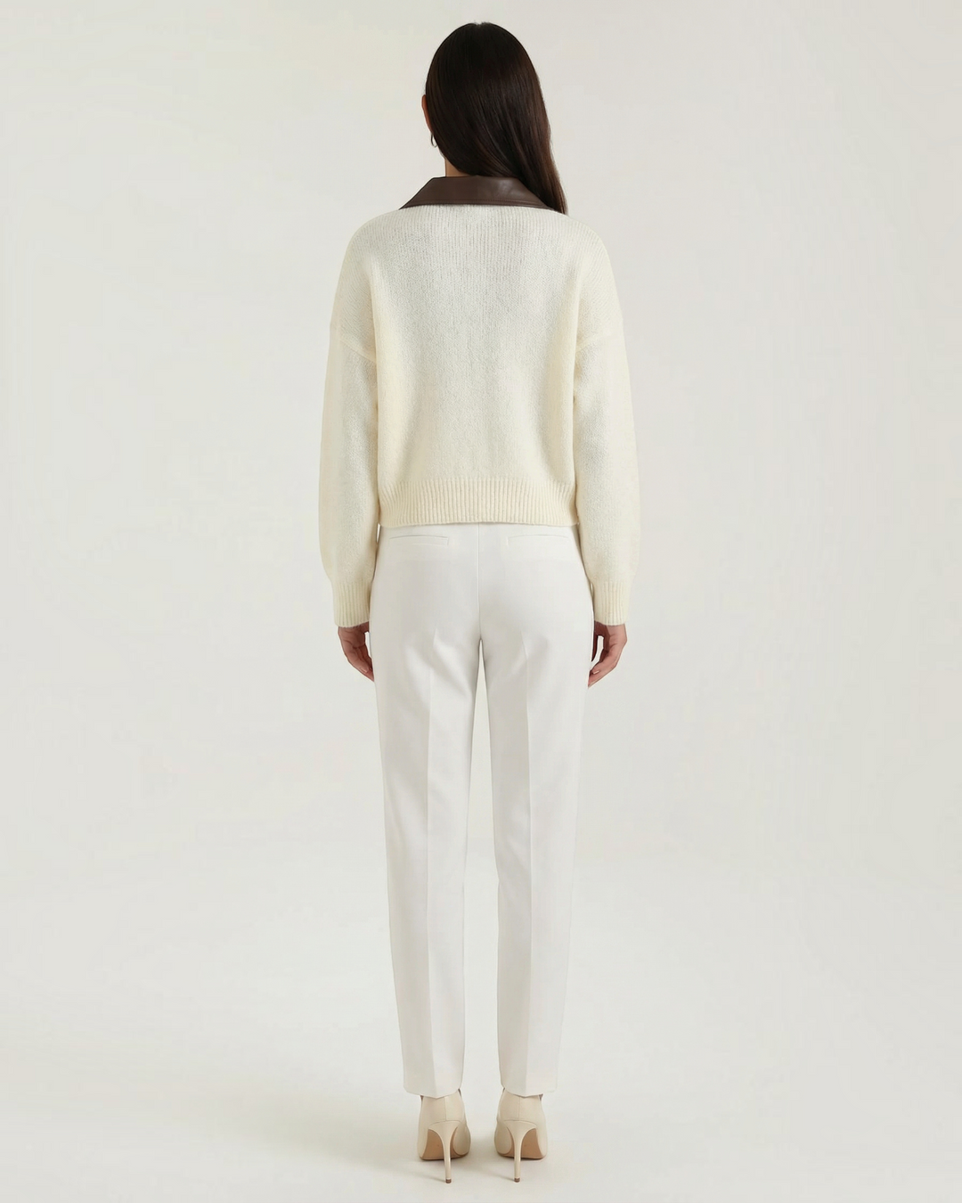 Luna Moda cropped cream cardigan with a brown contrast collar, seen from the back on a model wearing white trousers.
