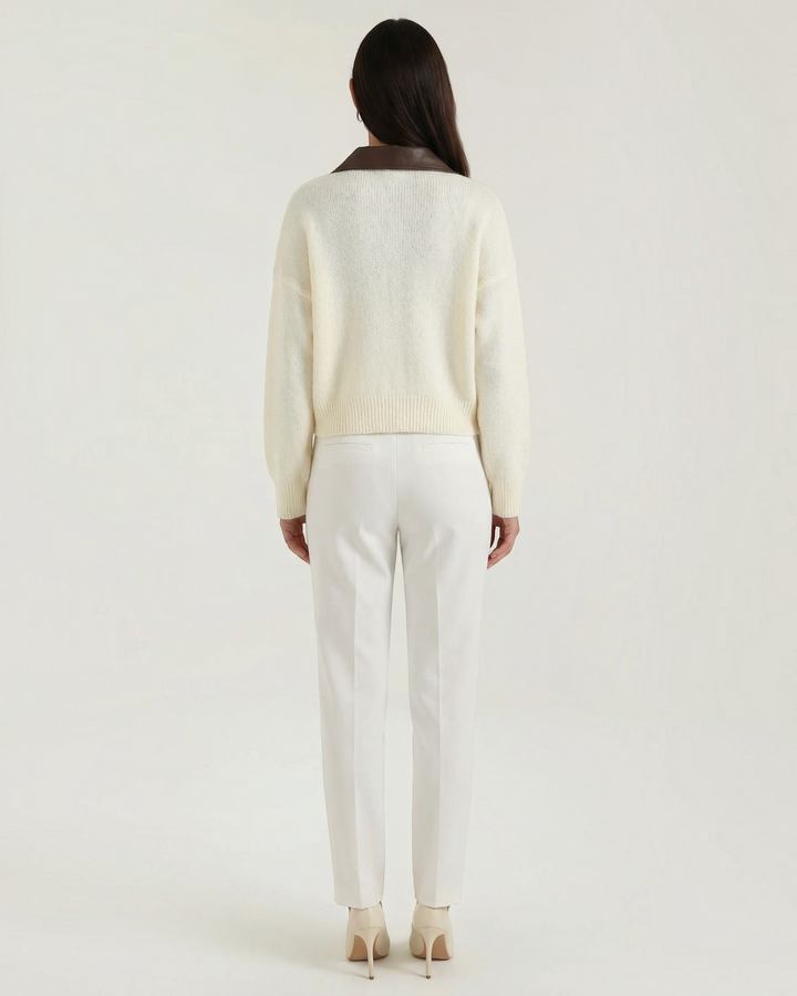 Luna Moda cropped cream cardigan with a brown contrast collar, seen from the back on a model wearing white trousers.