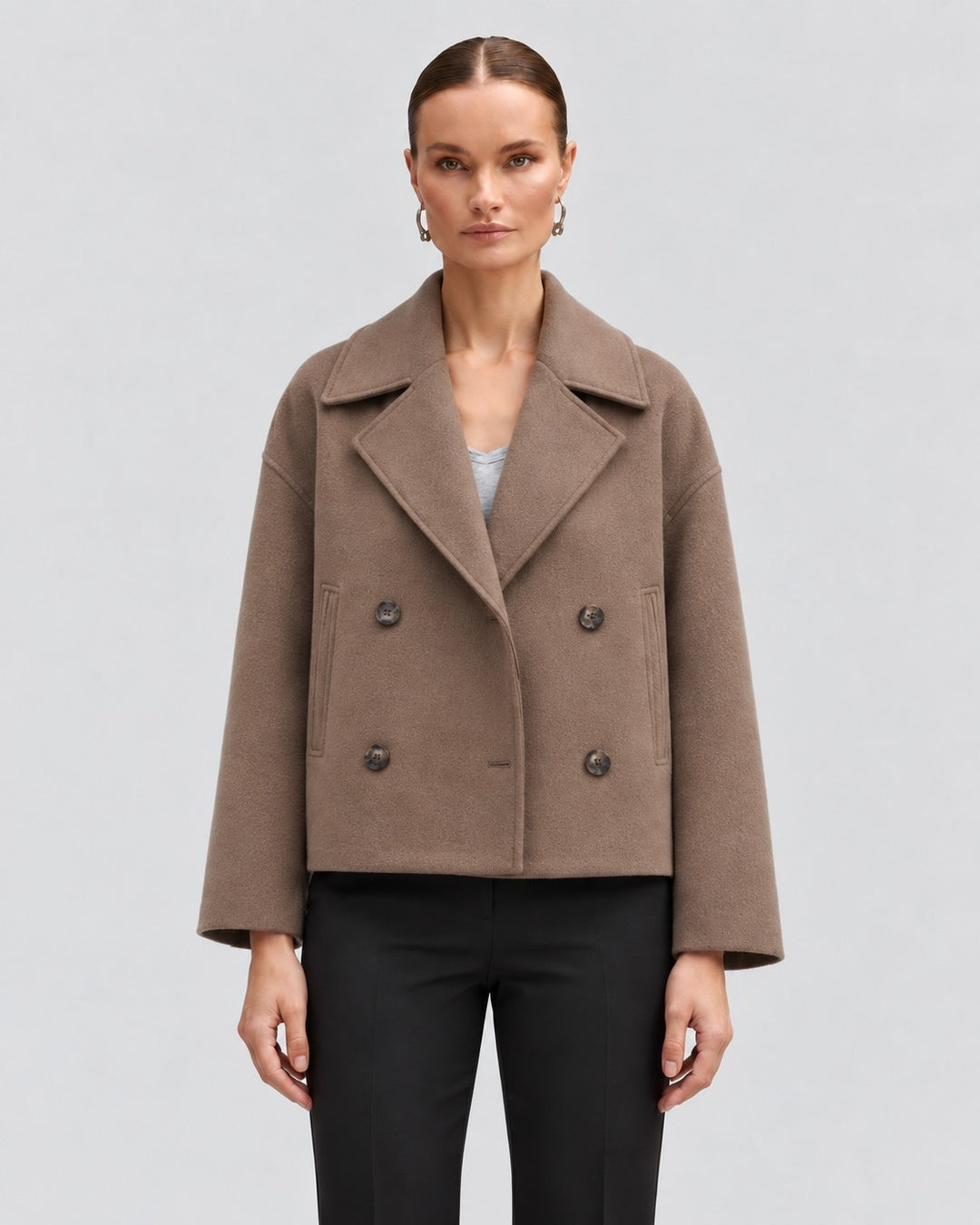 Luna Moda Costanza brown double-breasted short jacket with wide lapels worn by a model on a light grey background.