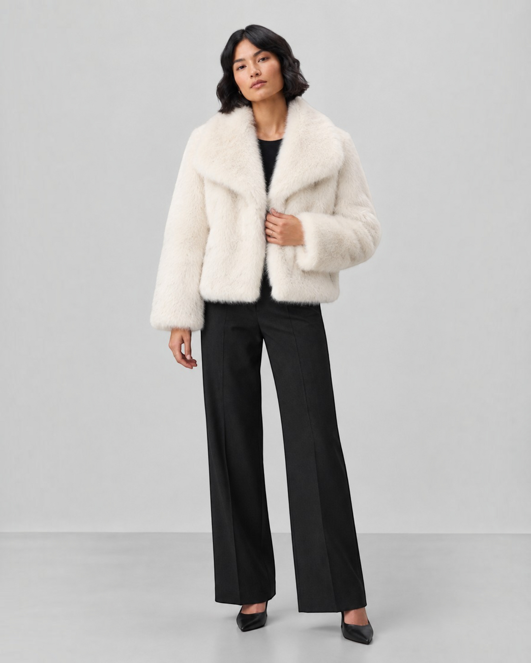 Luna Moda cream faux fur coat with a wide collar worn by a model with black trousers and heels