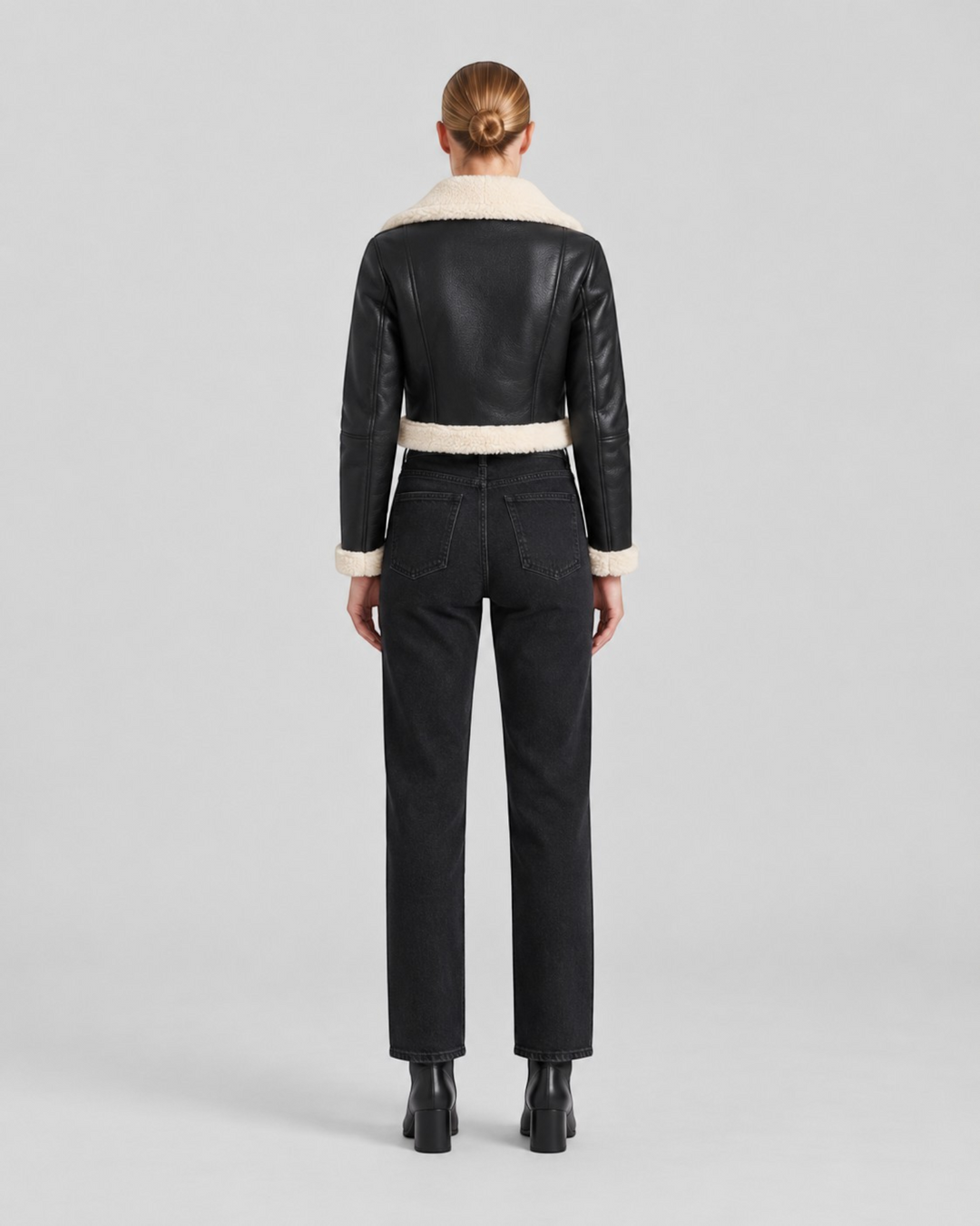 Luna Moda cropped black jacket with white faux shearling trim worn by a model from the back view