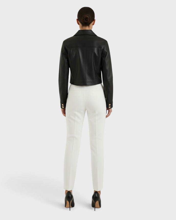 Luna Moda black faux leather cropped jacket worn by a model with white trousers and black heels, back view.