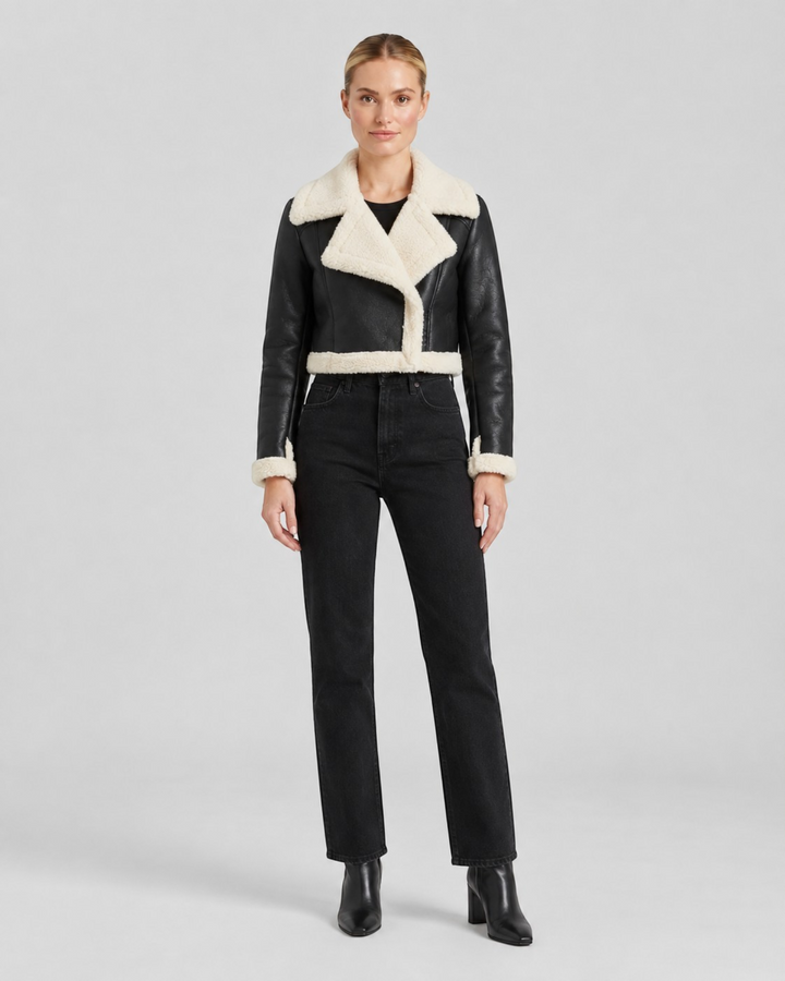 Luna Moda cropped black jacket with white faux shearling lining and collar worn by a model with black jeans