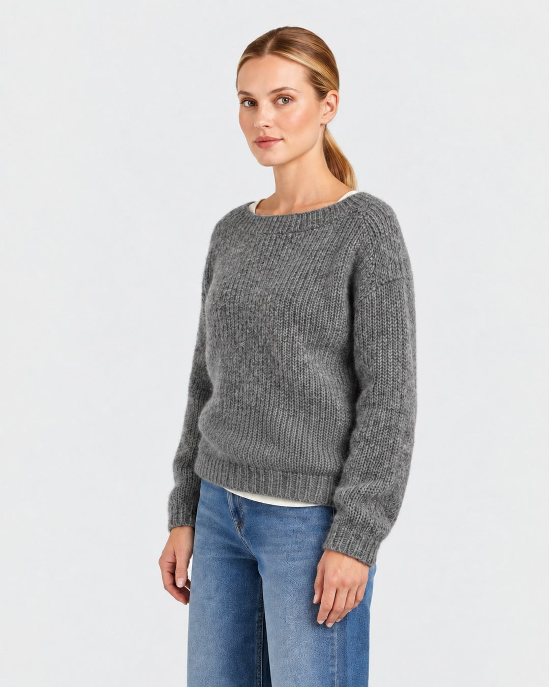 Luna Moda Elda grey crew neck sweater with a soft, chunky knit texture worn by a woman with blue jeans.