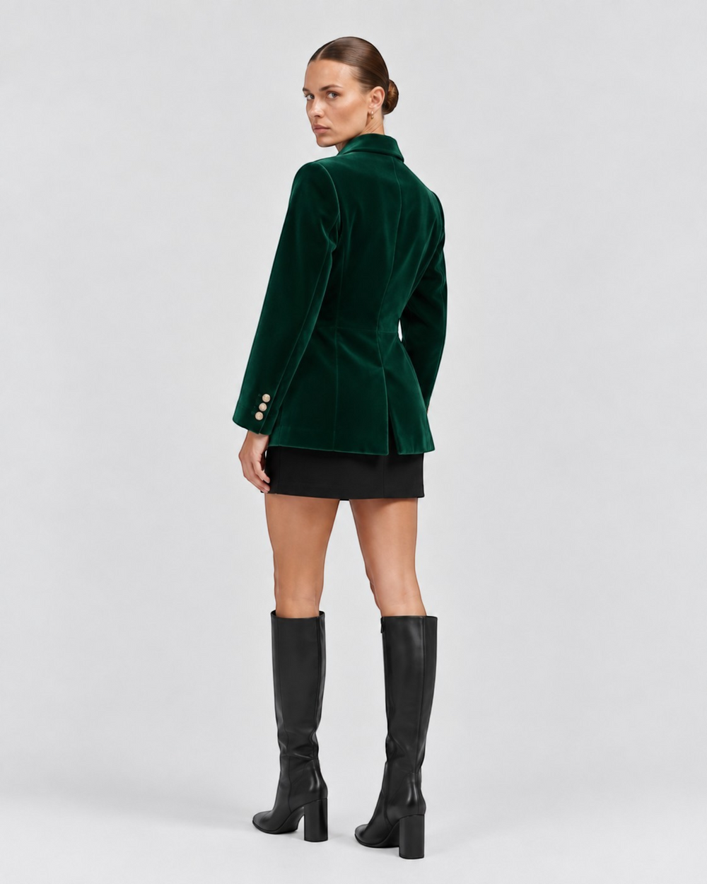 Luna Moda Natálie emerald green velvet tailored blazer worn by a model with a black skirt and knee-high boots