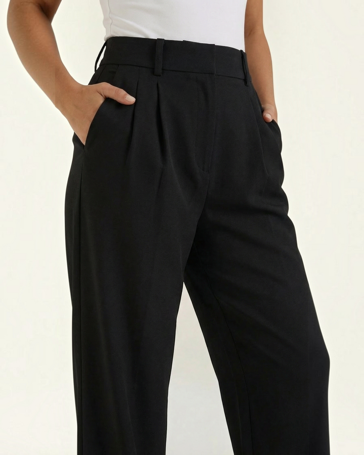 Luna Moda high-waisted black palazzo trousers with pleated details and side pockets on a model