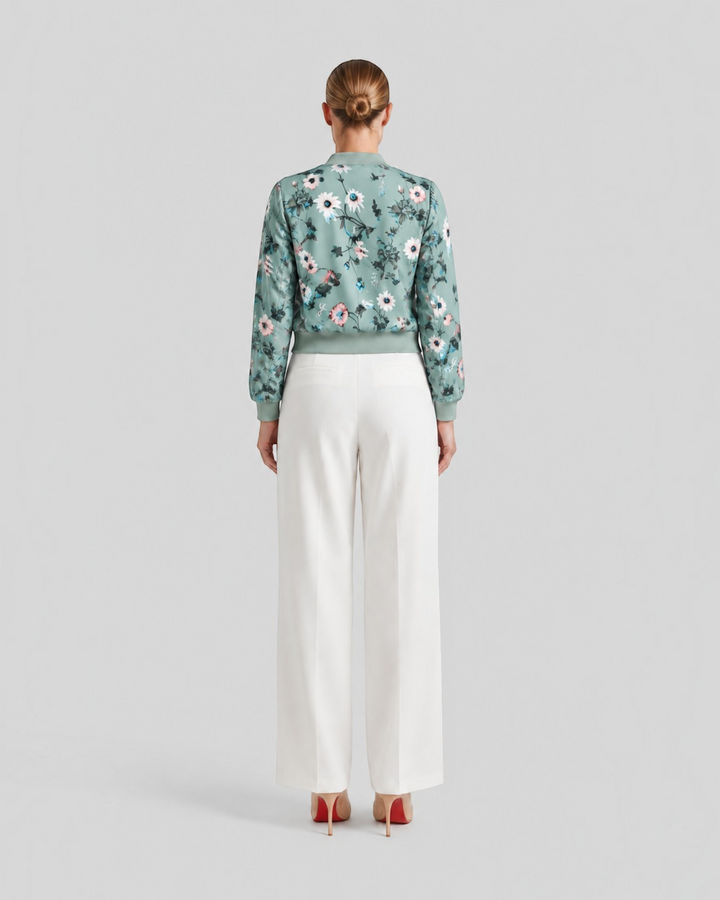 Luna Moda Arianna bomber jacket in sage green with floral print, worn with white trousers, back view