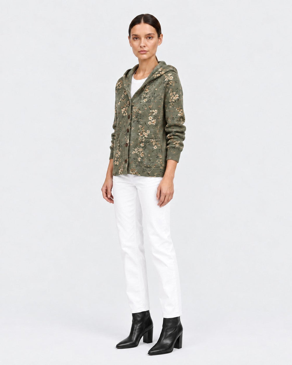 Luna Moda floral knit cardigan with hood in olive green, worn by a model with white trousers and black boots.