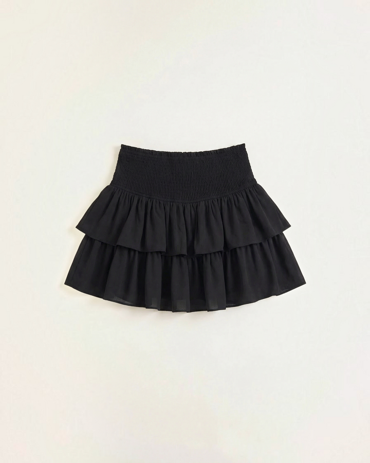 Luna Moda black mini skirt with a high-waisted smocked waistband and layered ruffled tiers in lightweight fabric.
