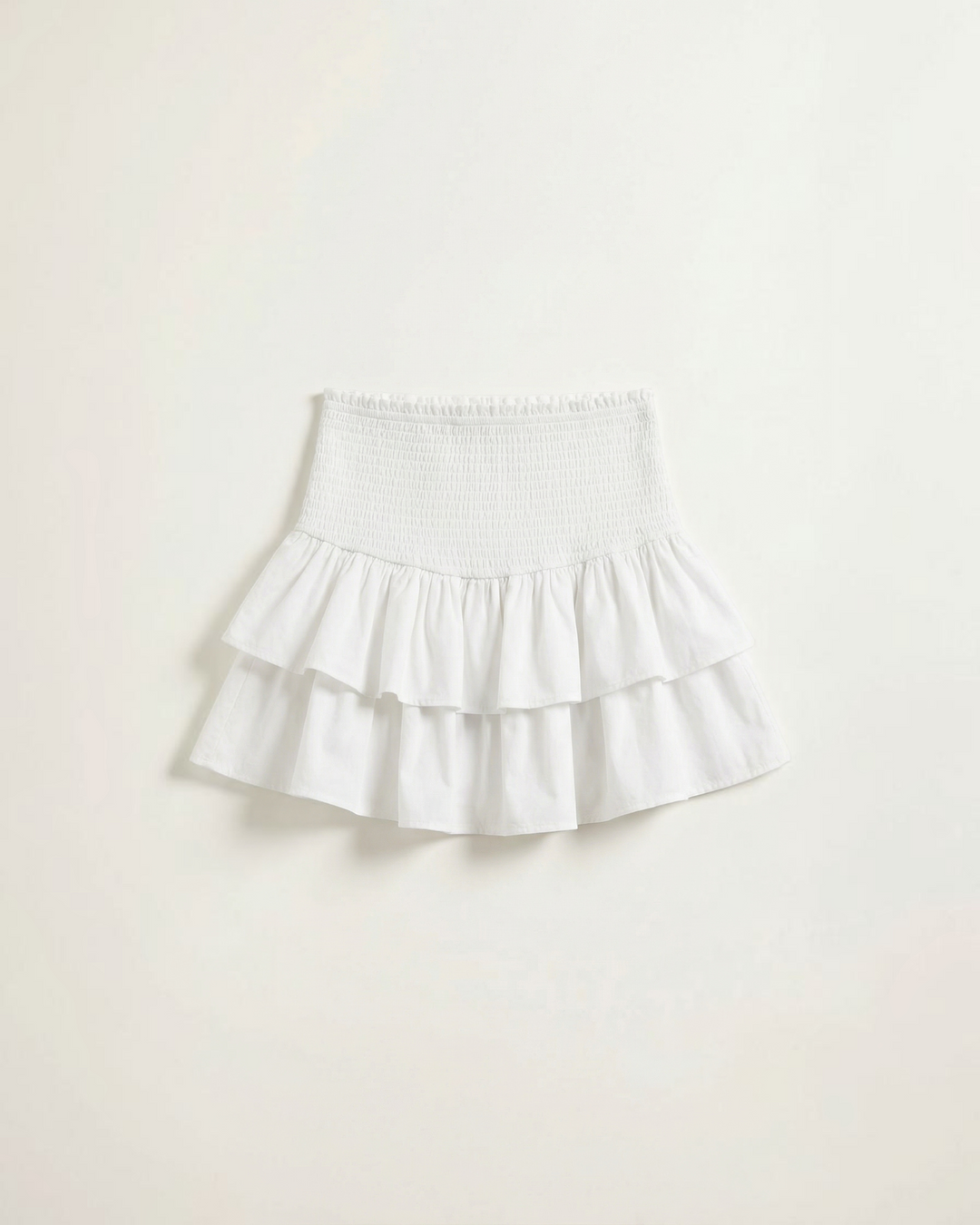 Luna Moda white mini skirt featuring a high-waisted smocked waistband and double-layered ruffled hem in lightweight fabric.
