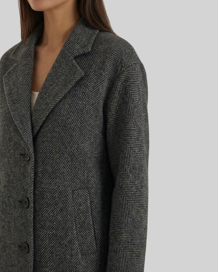Luna Moda ANNALENA long grey herringbone coat with notched lapels and button closure worn by a woman