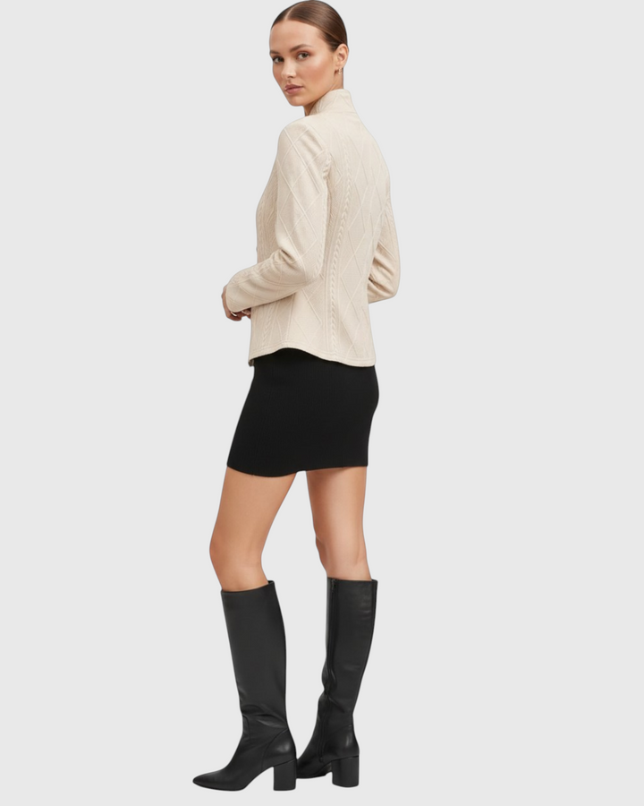 Luna Moda GRAZIA beige mid-season coat with cable knit texture worn by a model with a black skirt and tall boots.