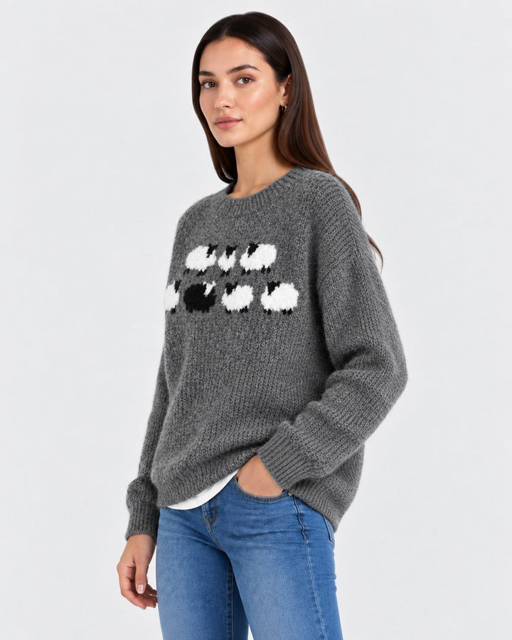 Luna Moda grey knitted sweater featuring a playful white and black sheep pattern worn by a woman with jeans