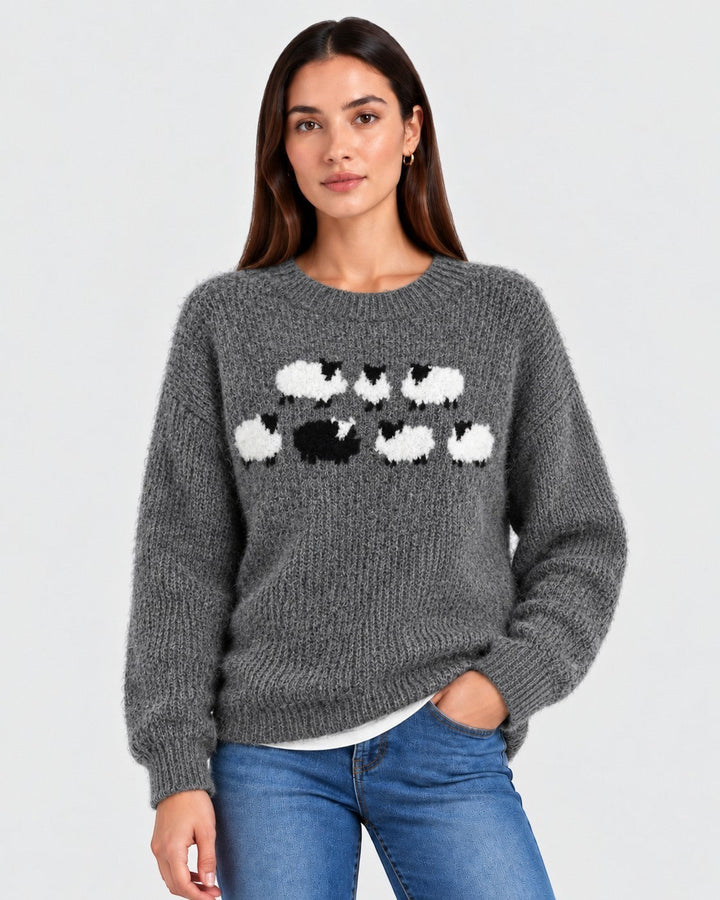 Luna Moda grey wool sweater featuring a playful white and black sheep pattern, worn by a woman with blue jeans.