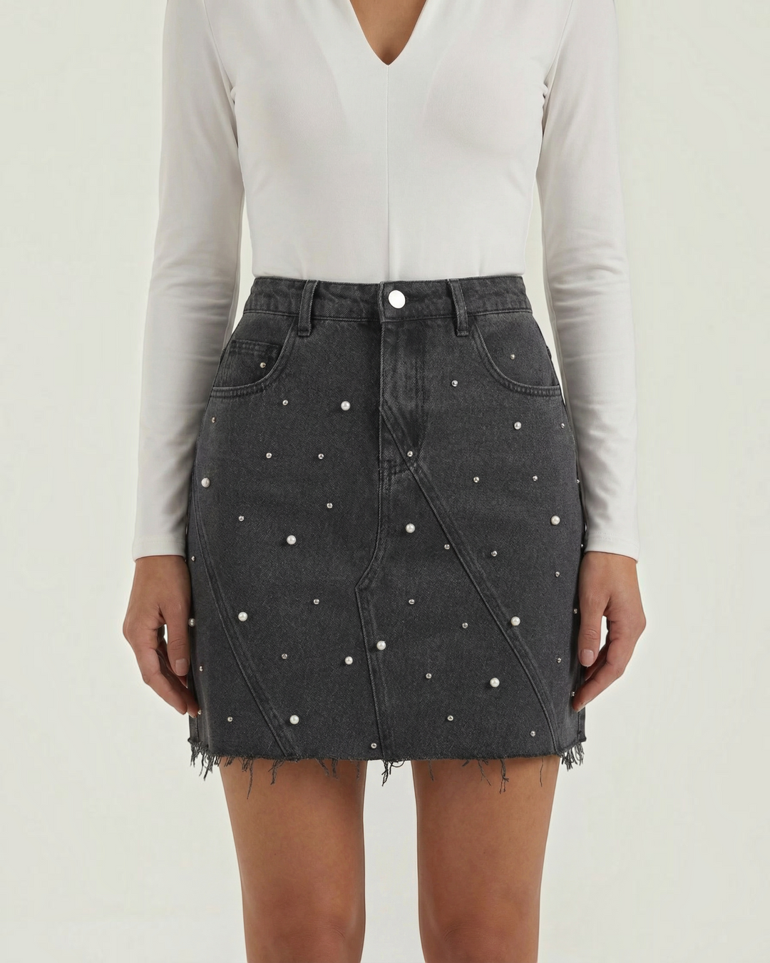 Luna Moda black denim mini skirt with scattered pearl embellishments and a raw frayed hem worn by a model.