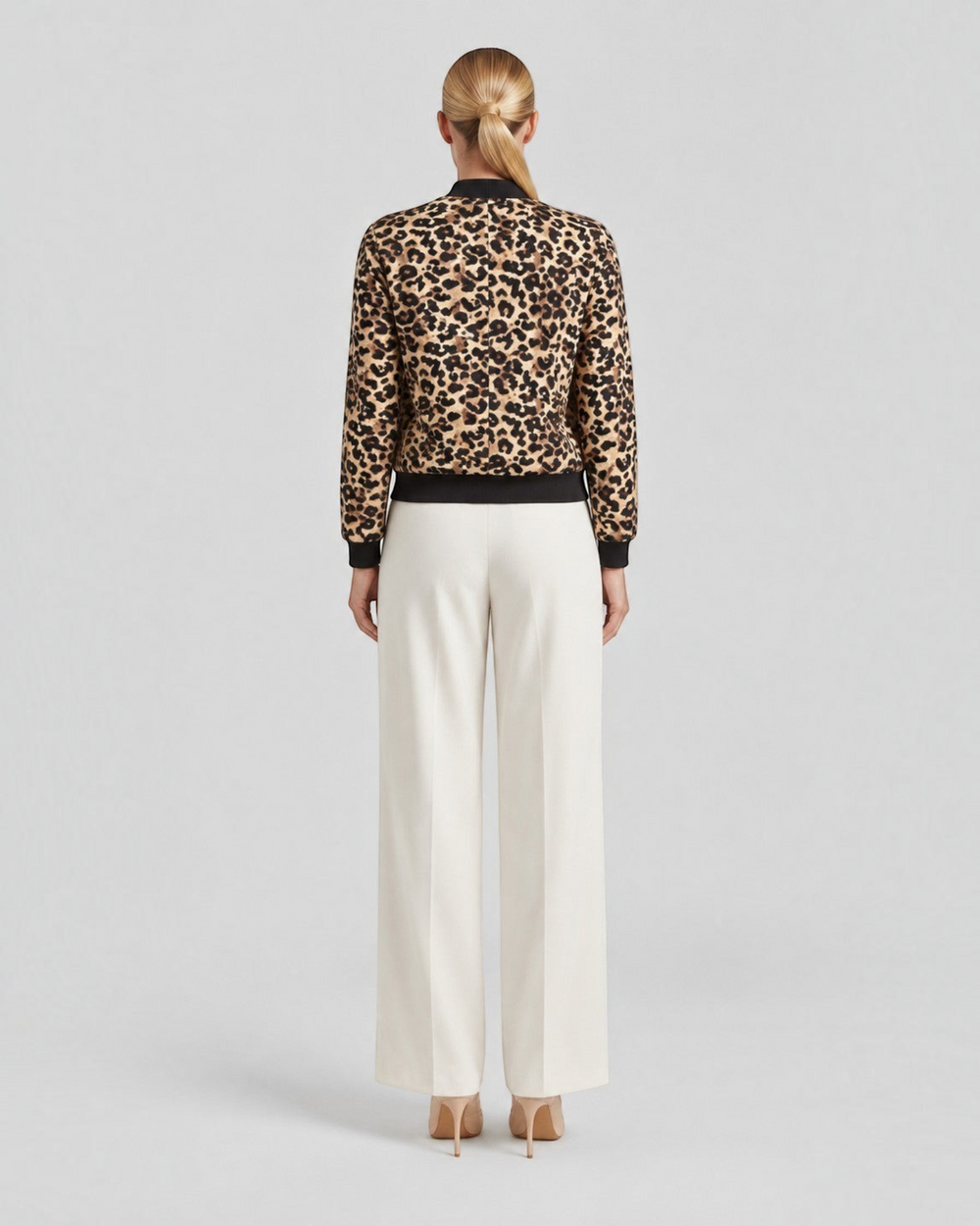Luna Moda leopard print bomber jacket with ribbed cuffs worn by a model from the back view with cream trousers