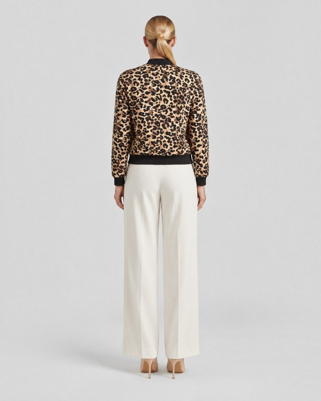 Luna Moda leopard print bomber jacket with ribbed cuffs worn by a model from the back view with cream trousers