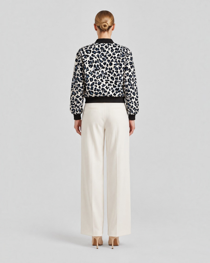 Luna Moda leopard print bomber jacket with ribbed cuffs worn by a woman with cream wide-leg trousers, back view