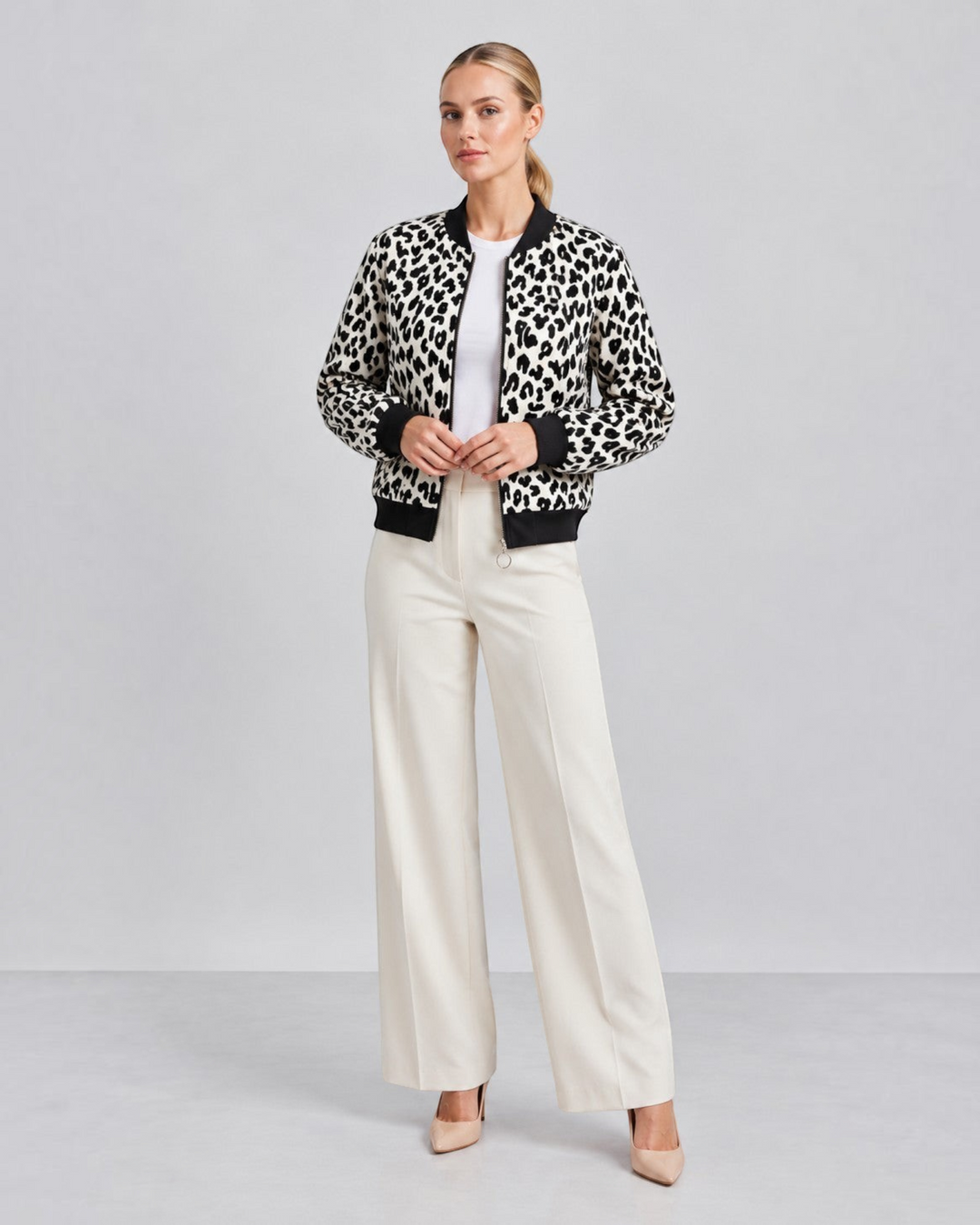 Luna Moda leopard print bomber jacket with black ribbed cuffs and collar worn by a model with white trousers