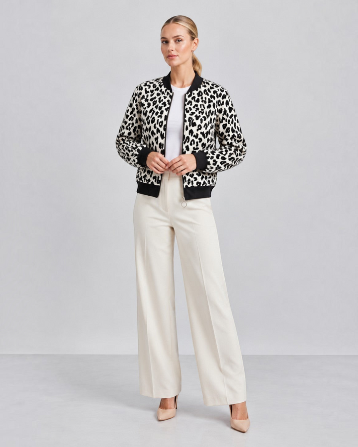 Luna Moda leopard print bomber jacket with black ribbed cuffs and collar worn by a model with white trousers