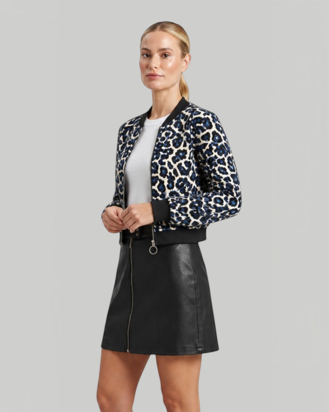 Luna Moda leopard print bomber jacket with ribbed cuffs worn by a model with a black leather skirt and brown boots