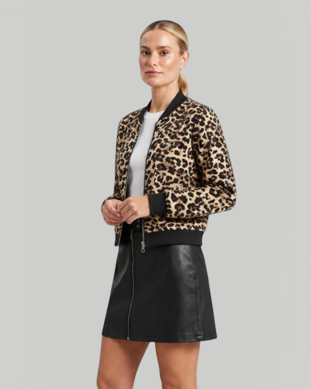 Luna Moda leopard print bomber jacket with black ribbed cuffs worn by a model with a black leather skirt