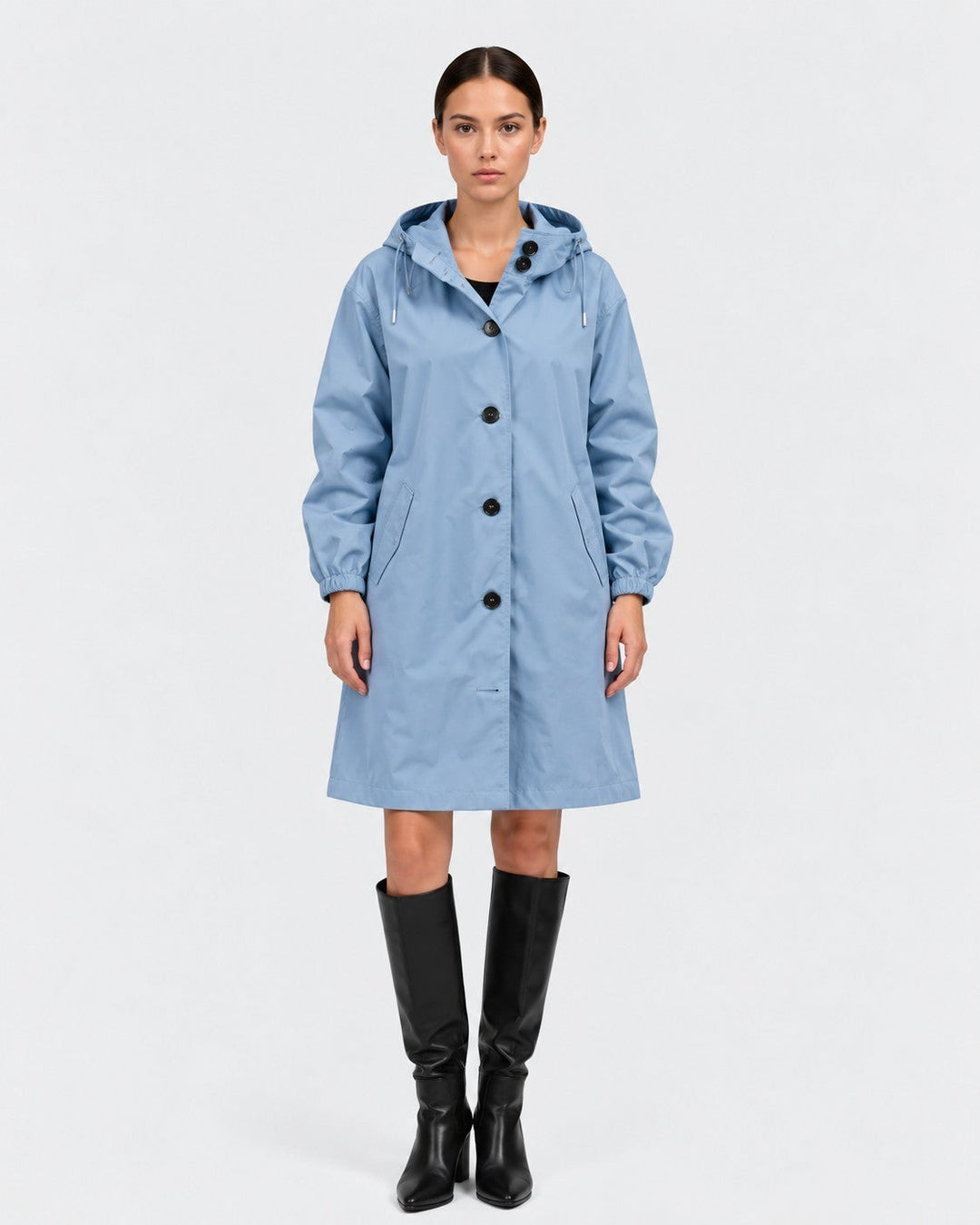 Luna Moda light blue oversized waterproof raincoat with hood and button closure worn by a model