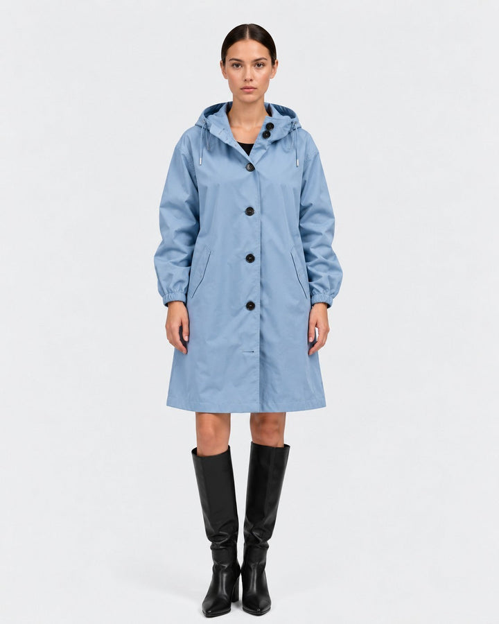 Luna Moda light blue oversized waterproof raincoat with hood and button closure worn by a model