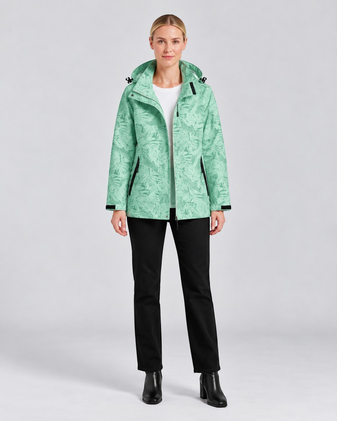 Luna Moda lightweight waterproof hooded jacket in light green with a tropical leaf print worn by a female model.