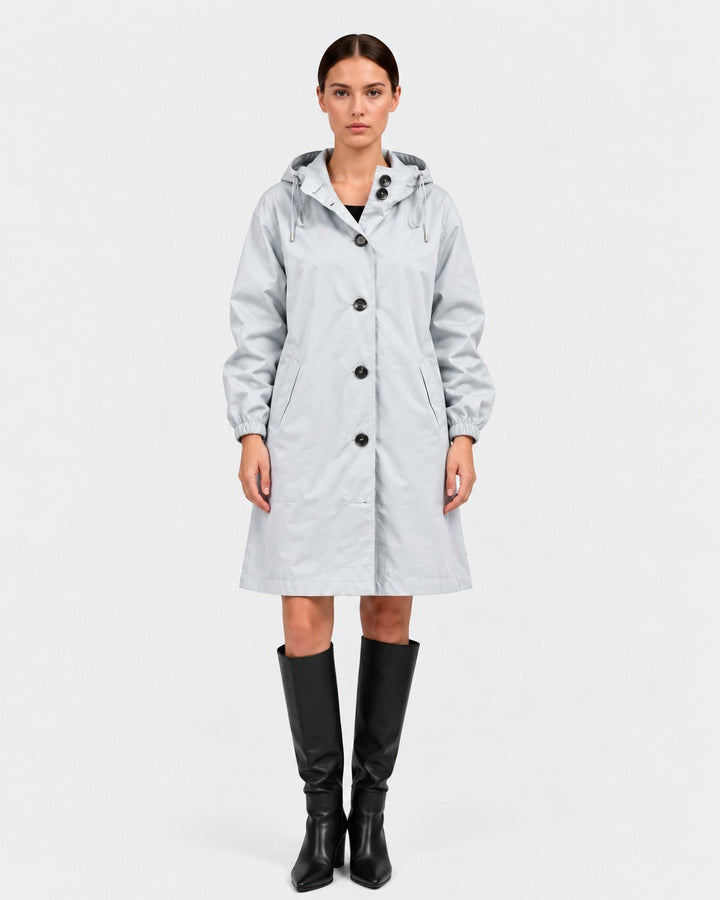 Luna Moda light grey oversized waterproof raincoat with hood and pockets worn by a model with black boots