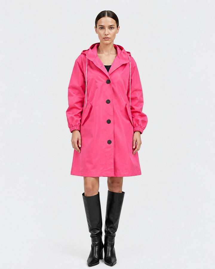 Luna Moda Lucie oversized hot pink waterproof hooded raincoat with button closure and pockets worn by a model