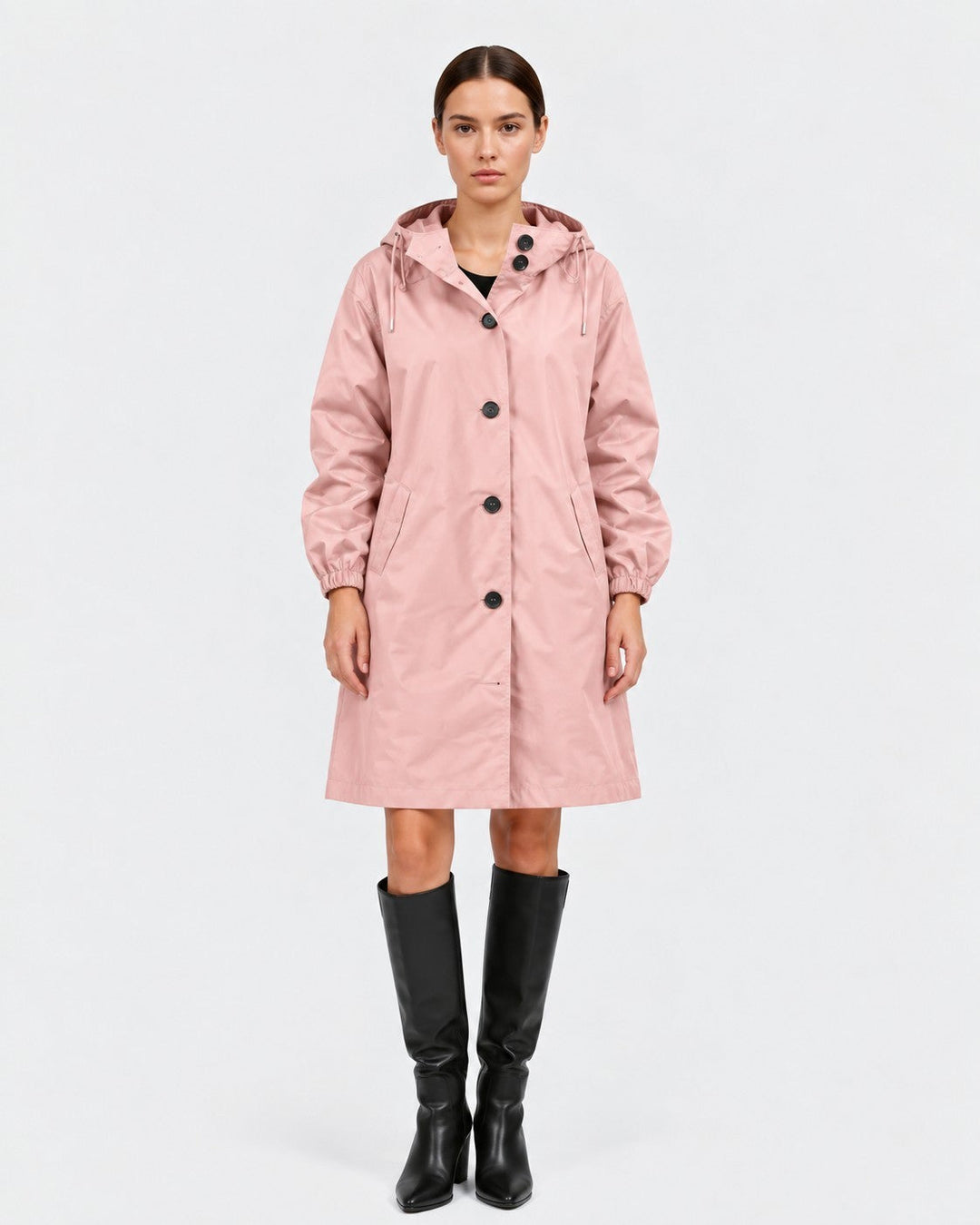 Luna Moda Lucie oversized waterproof pink raincoat with hood and pockets worn by a model with black boots