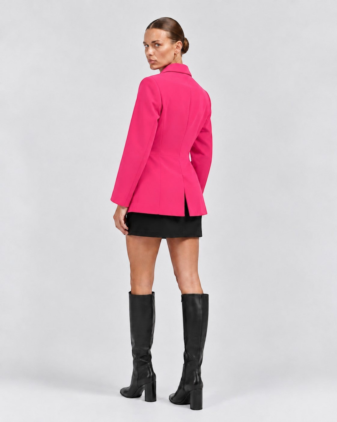 Luna Moda Margarida hot pink classic blazer worn by a model with a black mini skirt and knee-high boots, back view