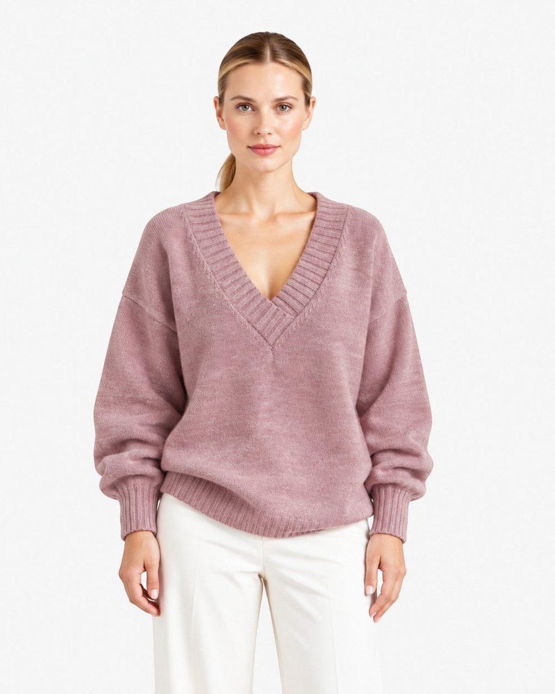 Luna Moda Nadia relaxed fit mauve cashmere blend sweater with a deep V-neck worn by a model with white trousers.