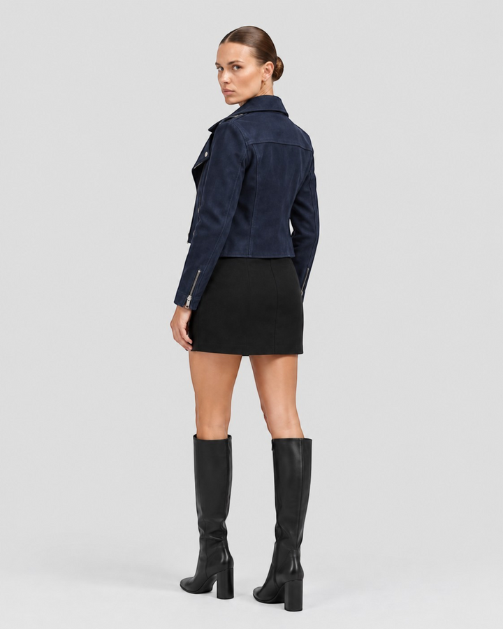 Luna Moda navy blue suede biker jacket with silver zippers worn by a model with a black skirt and knee-high boots