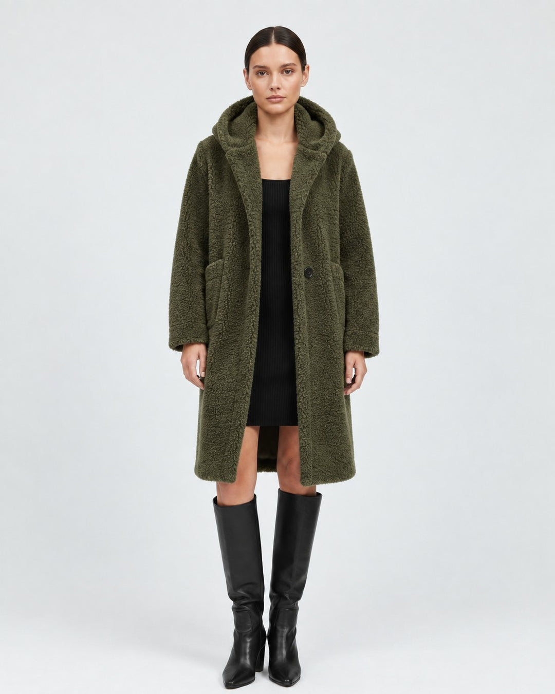 Luna Moda olive green hooded wool teddy coat with patch pockets, worn by a model over a black dress and boots.