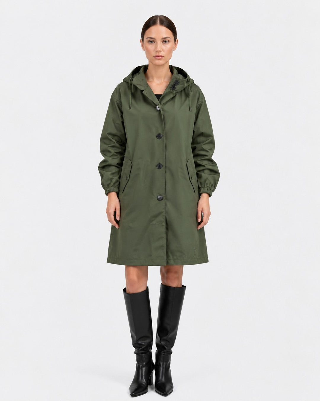 Luna Moda olive green oversized waterproof raincoat with hood and pockets worn by a model with black knee-high boots