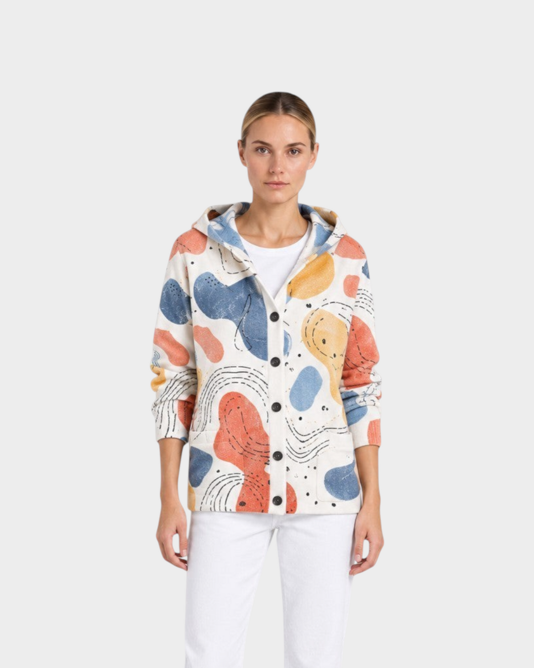 Luna Moda Ottavia hooded cardigan with a colorful abstract print, worn by a model with white jeans and black boots.