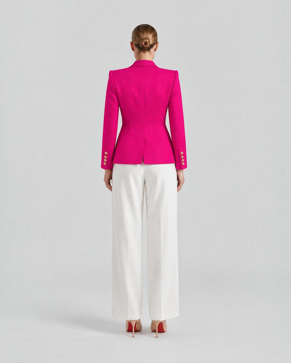 Luna Moda Paolina structured fuchsia blazer with gold decorative buttons, back view on a model with white trousers.